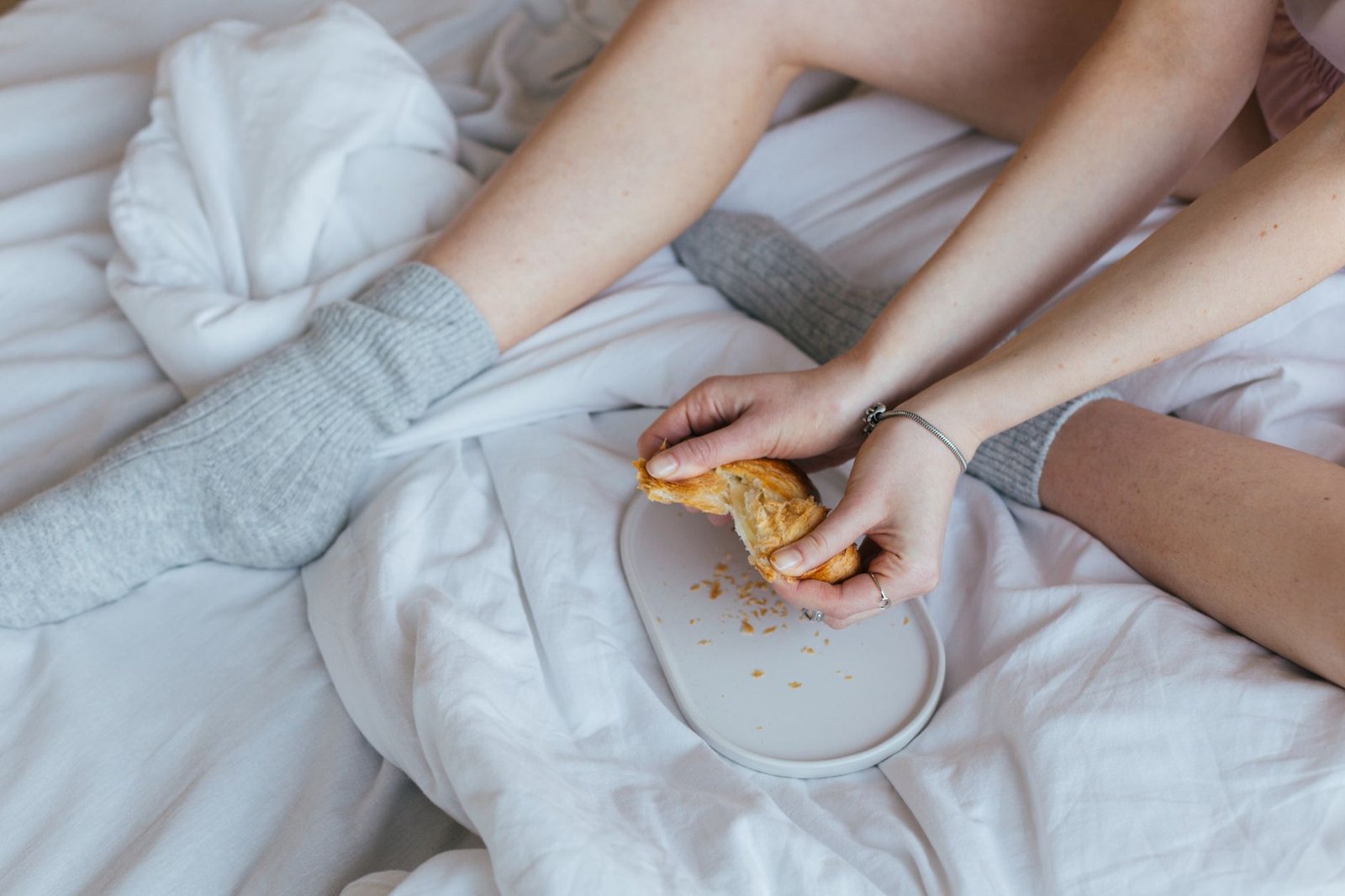 Woman wearing wool socks and flannel pajamas in bed