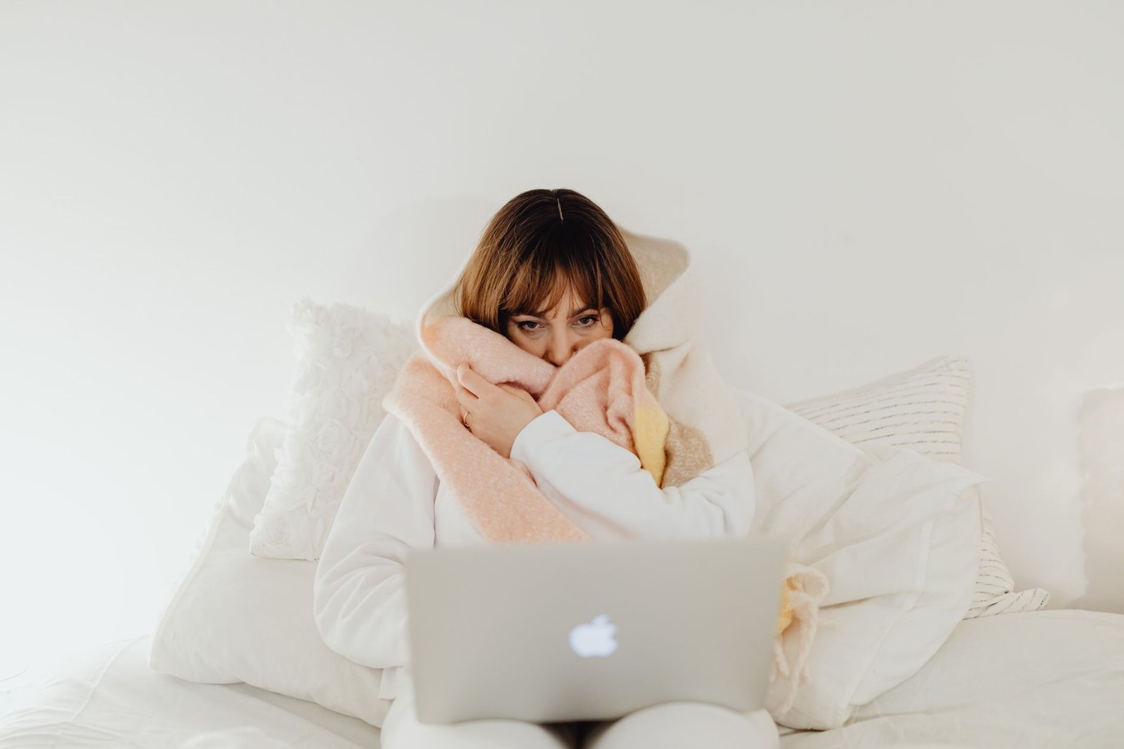 Woman wrapped in a thick blanket in her boyfriend's bed at night