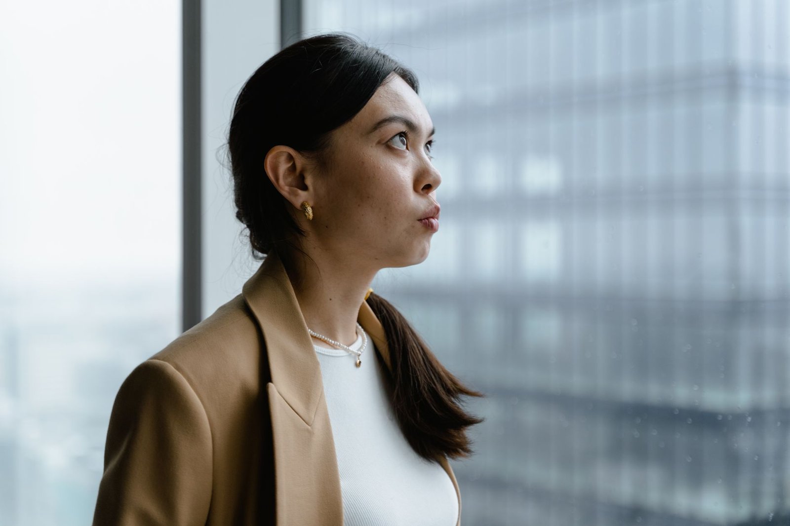 Woman looking out a window thinking about her partner's reaction