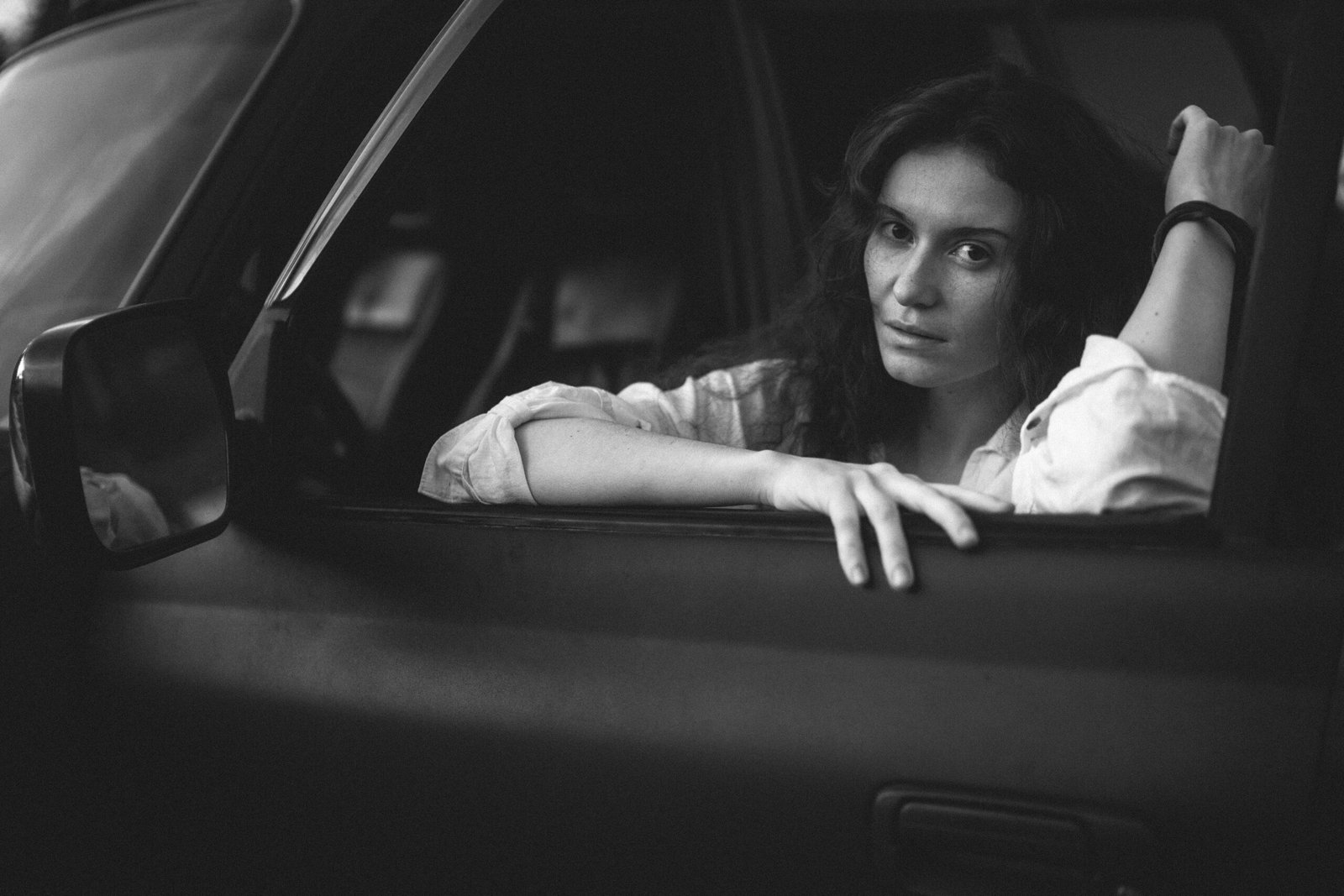 Woman looking out a car window, contemplative and deep in thought