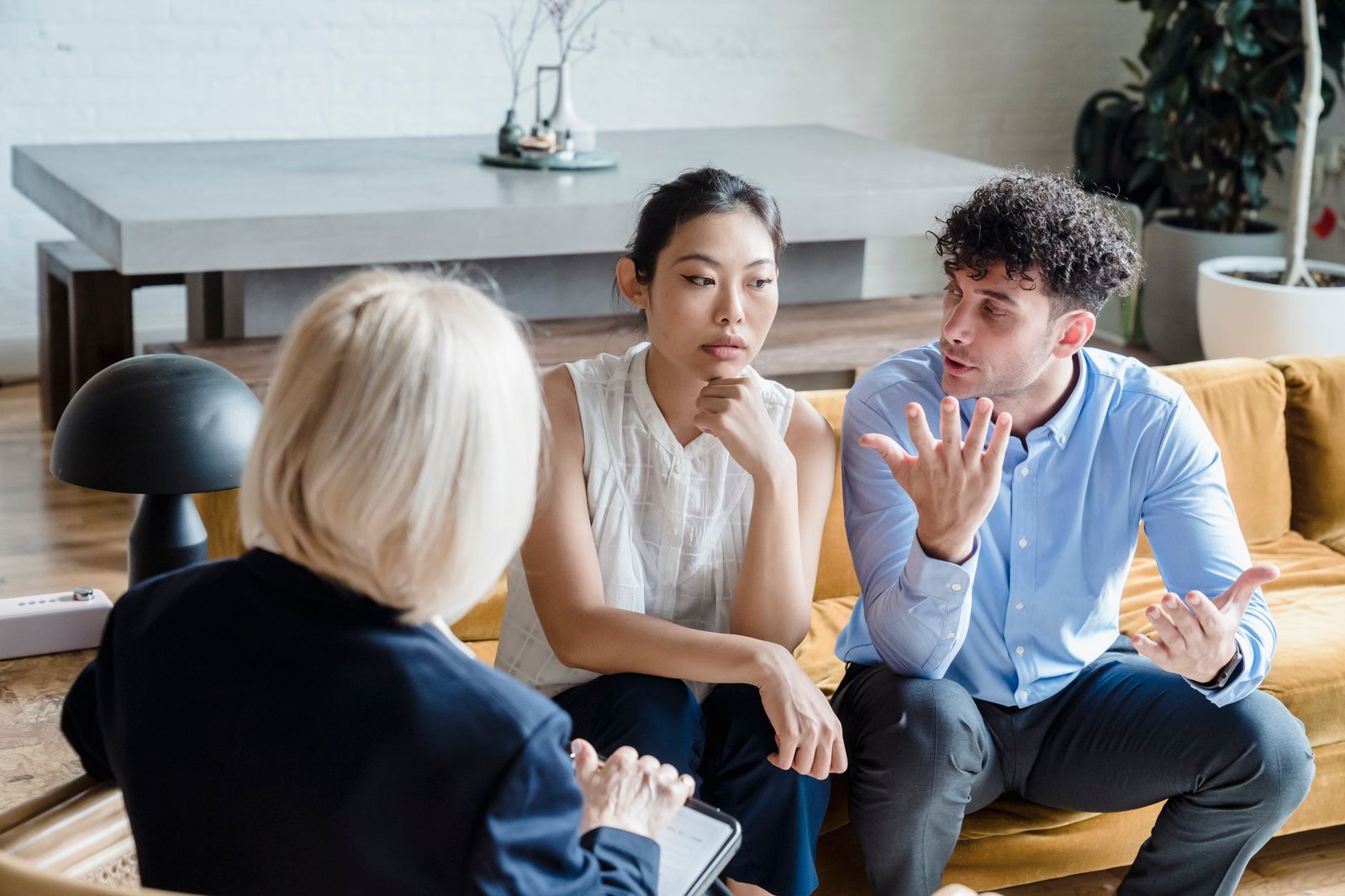 Couple having a serious talk on the sofa about whether to move closer to his parents