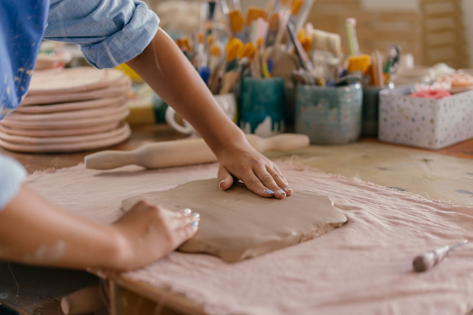 Woman working with pottery clay with her hands